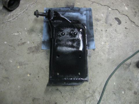 1989 Ford Bronco - Automotive part freshly painted black, resting on a shop towel on a concrete surface.