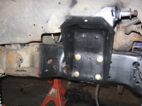 1989 Ford Bronco - Close-up view of vehicle frame and suspension parts, with a black bracket attached.