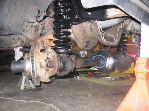 1989 Ford Bronco - Close-up view of front axle and suspension components, likely during installation or repair.