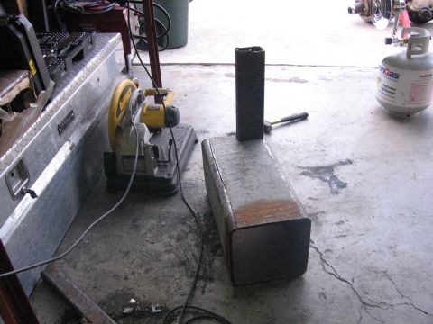 1989 Ford Bronco - Metal fabrication setup with a chop saw, toolbox, propane tank, and cut metal pieces.