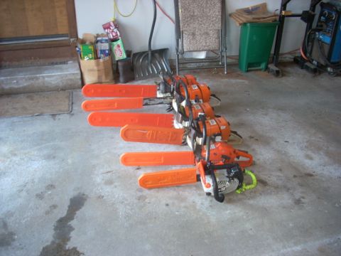 2000 Chevrolet Tahoe - Multiple chainsaws are lined up in a garage setting.