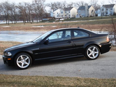 1998 Ford Taurus - Side view of a black coupe with distinctive five-spoke wheels parked on a paved surface.