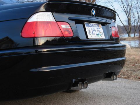 1998 Ford Taurus - The rear of a black BMW M3 is shown, its distinctive quad exhaust tips and a spoiler.