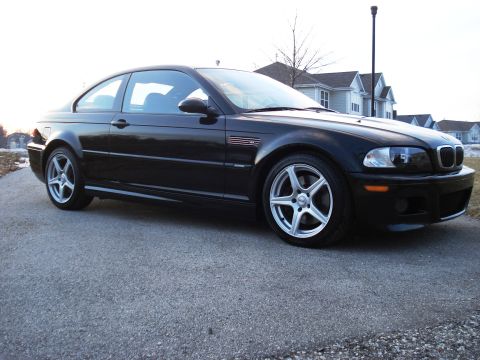 1998 Ford Taurus - Black BMW M3 coupe with aftermarket wheels is shown from the front 3/4 angle.