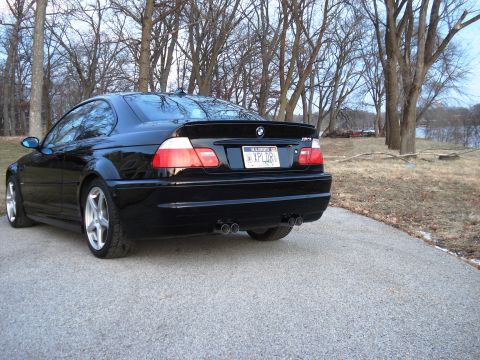 1998 Ford Taurus - Rear view of a black BMW M3 coupe, identifiable by its distinctive taillights, spoiler, and quad exhaust.
