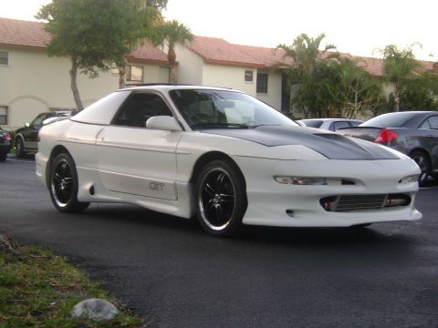 1994 Ford Probe - A white 1994 Ford Probe is parked in a lot with other vehicles visible.