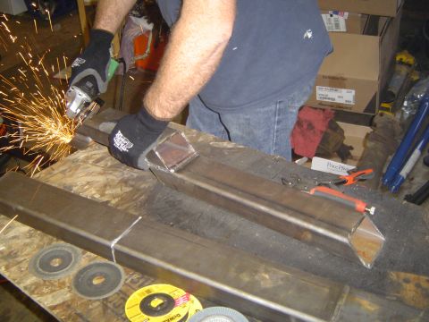 1979 Ford Bronco - Grinding metal tubing on a workbench with sparks flying.