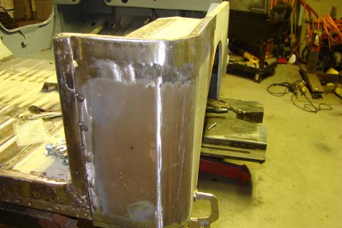 1948 Jeep Wrangler - The rear body panel of a vehicle is shown with fresh welds and body filler, indicating ongoing repair work.