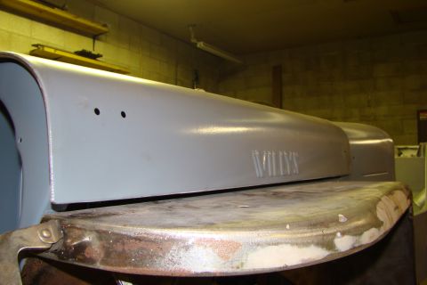 1948 Jeep Wrangler - A gray painted Willys hood panel is shown in a workshop setting, with embossed lettering visible.