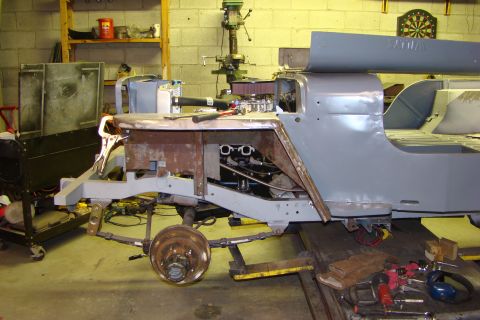1948 Jeep Wrangler - Jeep Wrangler body and frame in shop for restoration work, showing engine and suspension.