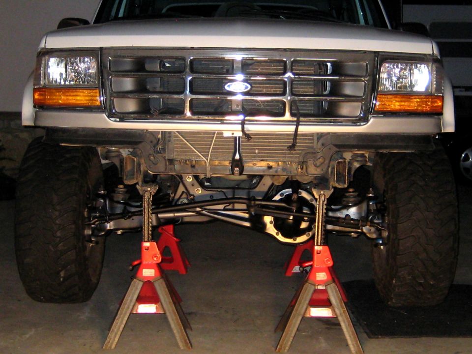 1996 Ford Bronco front end lifted on jack stands, showing suspension and grille