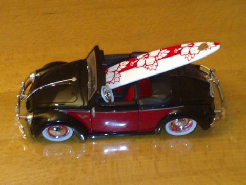 1991 Ford Crown Victoria - A toy convertible with a surfboard loaded in the passenger seat sits on a wooden surface.