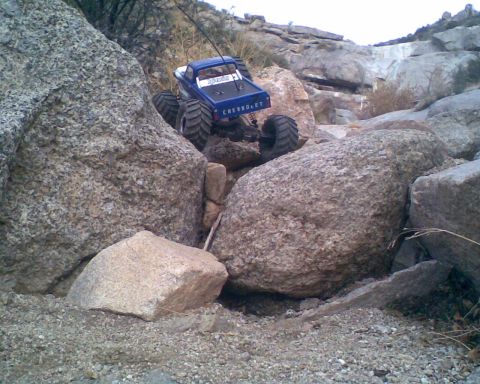 1984 Ford Bronco II - An RC rock crawler navigates a rocky, off-road terrain.