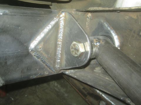 1990 Ford Bronco - close-up shows a welded triangular gusset plate and bolt joining tubular members on a fabricated chassis.