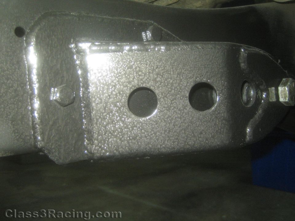 Close-up of a textured-coated steel suspension bracket with holes