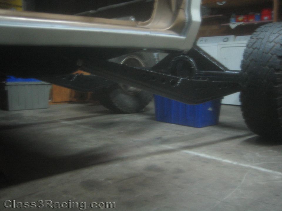 Underside view of a project truck showing fabricated suspension links