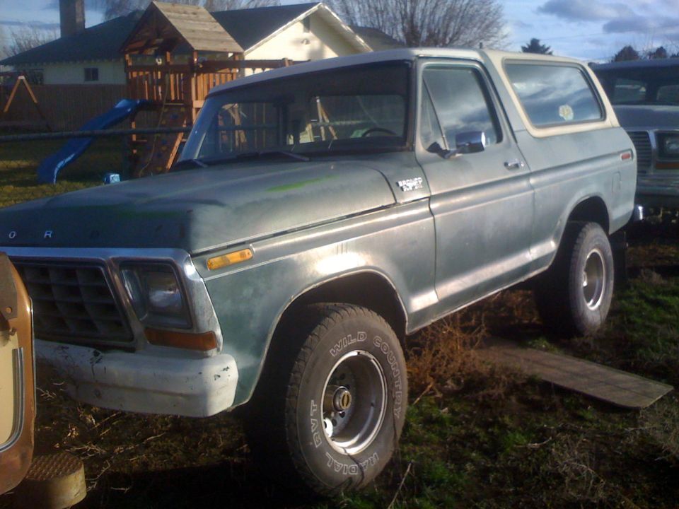 1983 Ford Bronco parked on grass with playground in background