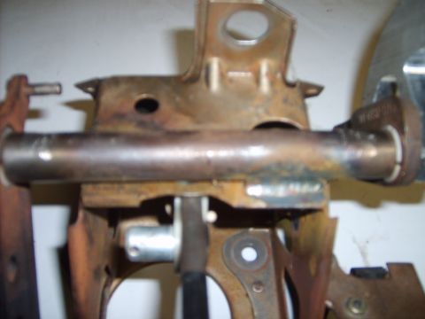 1993 Ford Crown Victoria - This is a close-up view of a rusty metal bracket assembly, likely from a vehicle's steering column.