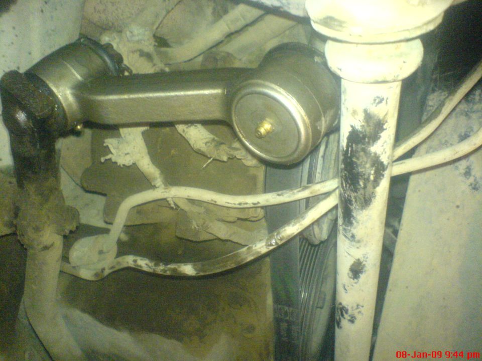 Close-up of vehicle suspension parts: tie rod end, sway bar link, steering column.