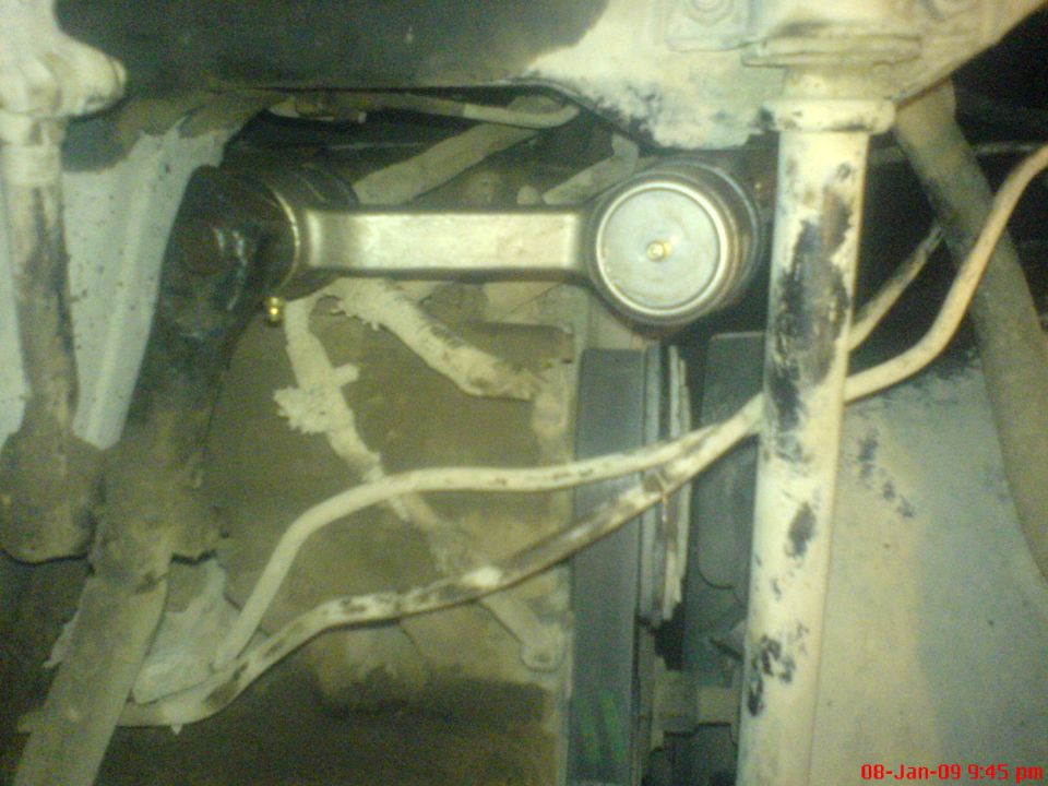 Close-up of a vehicle's metallic suspension component, possibly a tie rod end.