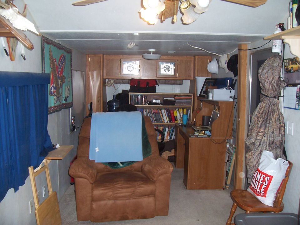 Camper interior with recliner, bookshelves and a desk