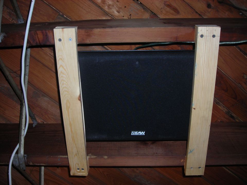 Black EAW speaker mounted on wooden beams in an attic