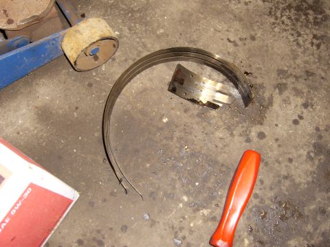 1972 Ford Ranchero - A set of worn piston rings and a broken piece of metal are lying on a concrete floor next to a blue hydraulic jack and a red-handled tool.…