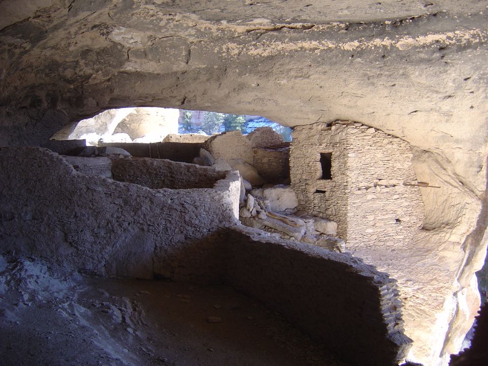 Ancient stone cliff dwellings built into a rock overhang.
