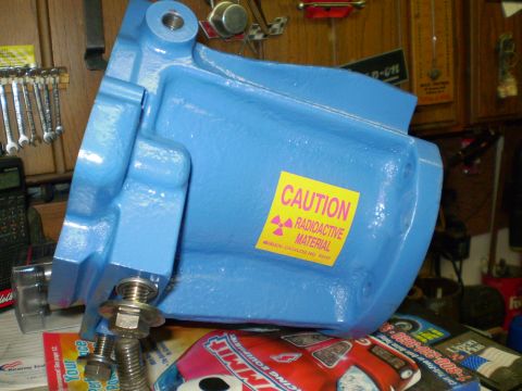 1978 Ford Bronco - A bright blue painted metal part, possibly a vehicle component, is shown with a yellow caution sticker indicating radioactive material. The…