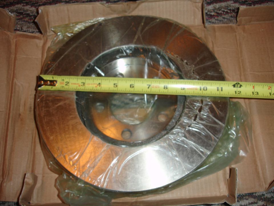 New brake rotor in box with measuring tape showing 11.5 inch diameter.