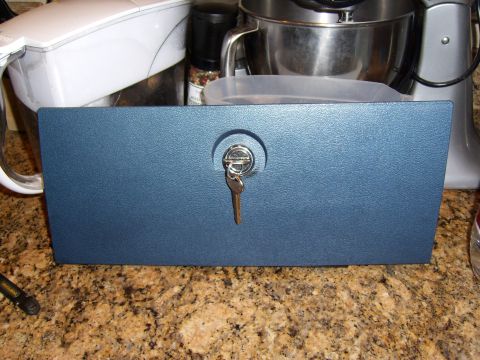 1972 Ford Ranchero - A blue lockbox with a key inserted is displayed on a speckled countertop. In the background, kitchen appliances are visible.