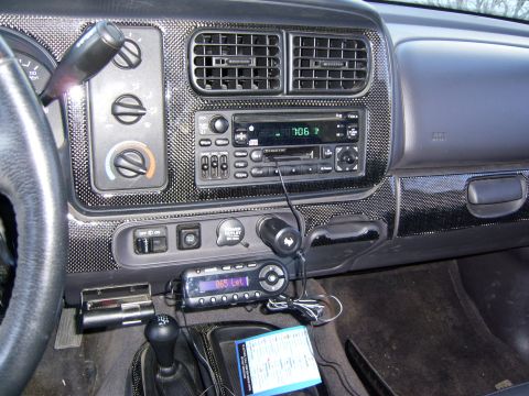 1972 Ford Ranchero - The interior of a vehicle's dashboard is shown, featuring a carbon fiber-like trim around the center console and radio. Visible controls in…