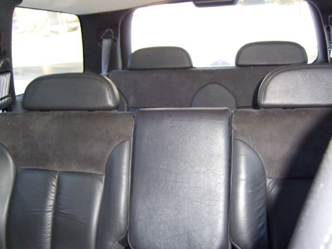 1972 Ford Ranchero - The interior of a vehicle shows the back seats and headrests with leather upholstery. A seatbelt is visible on the right side of the image.