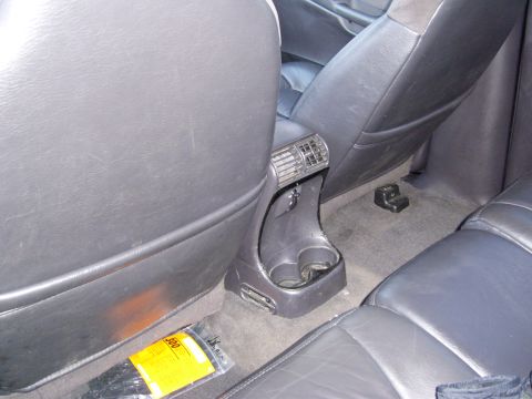1972 Ford Ranchero - The interior of a vehicle shows the back seats and a center console with cup holders and air vents. A package of zip ties is visible on the…