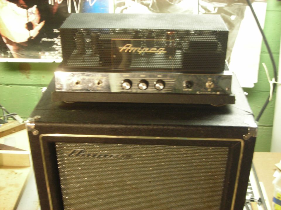 Ampeg bass amplifier head on top of an Ampeg bass cabinet.