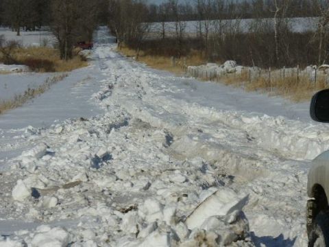 1978 Ford F-150 - A vehicle navigates a challenging, snow-covered rural road with deep tracks and debris.