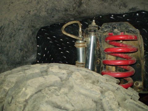 1978 Ford Bronco - Close-up view of a vehicle's suspension system, including a tire and shock absorber.