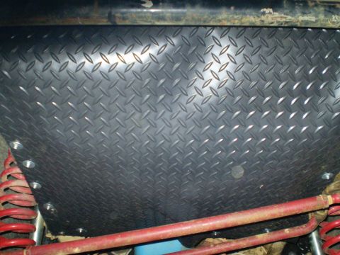 1978 Ford Bronco - Undercarriage view of a diamond plate skid plate, with visible red suspension components and a Supermotors.net watermark.