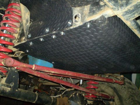 1978 Ford Bronco - Close-up view of the underside of a vehicle, highlighting the skid plate and suspension system.