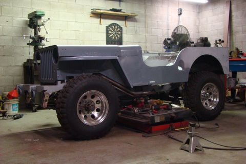 1948 Jeep Wrangler - This Jeep body, possibly a CJ-2A or CJ-3A, is undergoing modifications in a workshop setting.