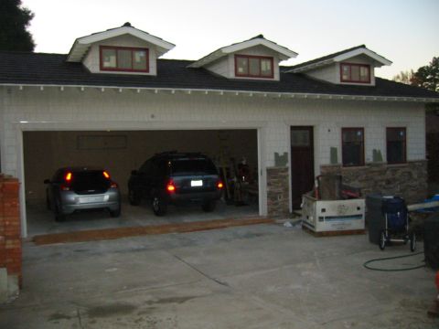 1992 Ford Bronco - Two SUVs are parked inside a garage, with the garage door open to the driveway.