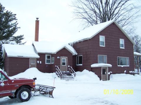 1989 Ford F-150 - A red 1989 Ford F-150 pickup truck equipped with a snow plow is parked in front of a house during winter.