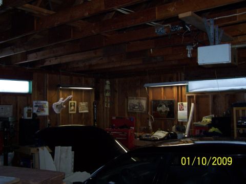 1989 Ford F-150 - A dark garage interior with multiple vehicles and various items on the walls.