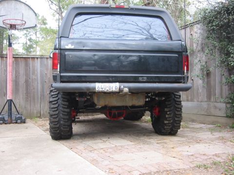 1995 Ford Bronco - Rear view of a black lifted SUV with oversized tires and a custom bumper, parked outdoors.