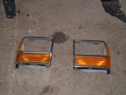 1990 Ford Ranger - A pair of front turn signal and parking light assemblies are shown, possibly for a Ford Ranger, resting on a garage floor.