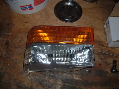 1990 Ford Ranger - A clear corner headlight assembly with an amber turn signal is shown on a wooden surface.