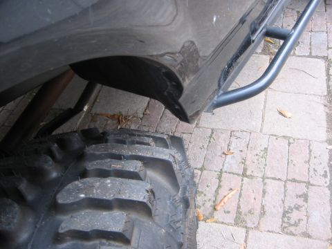 1995 Ford Bronco - This image shows a close-up of an off-road tire and a rock slider, not a full vehicle.