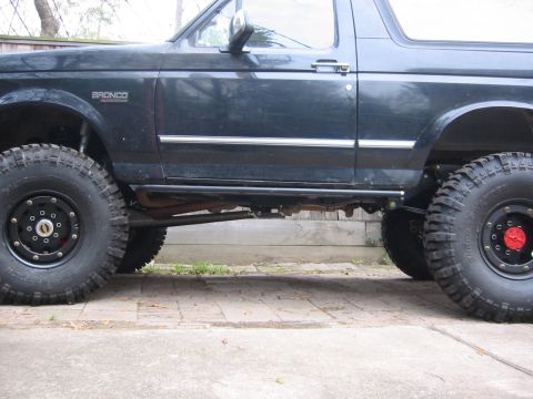 1995 Ford Bronco - Side view of a modified 1995 Ford Bronco with oversized tires and custom side steps.