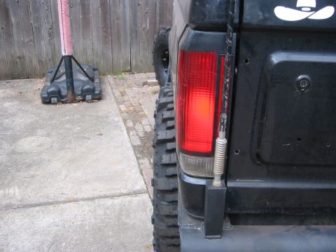 1995 Ford Bronco - Rear view of a 1995 Ford Bronco showing its taillight and off-road tire, with a cowboy hat sticker.