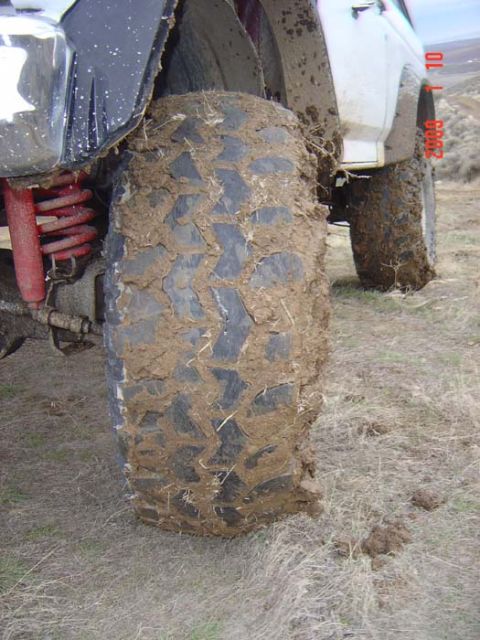 1983 Ford Bronco - This vehicle's tire is heavily covered in mud, suggesting it has been driven off-road.
